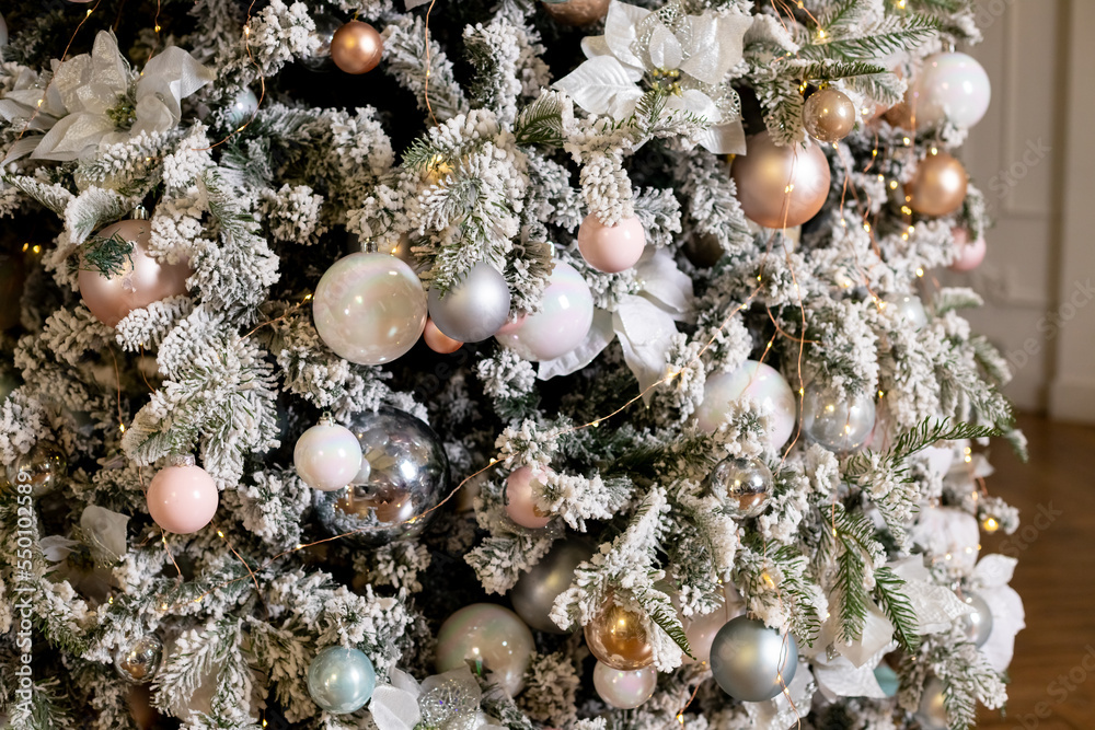festive decor,Christmas decorations on the snow-covered branches of an artificial Christmas tree.New Year's background. winter holidays, home interior festive decor,Christmas decorations on the snow-covered branches of an artificial Christmas tree.New Year's background. winter holidays, home interior