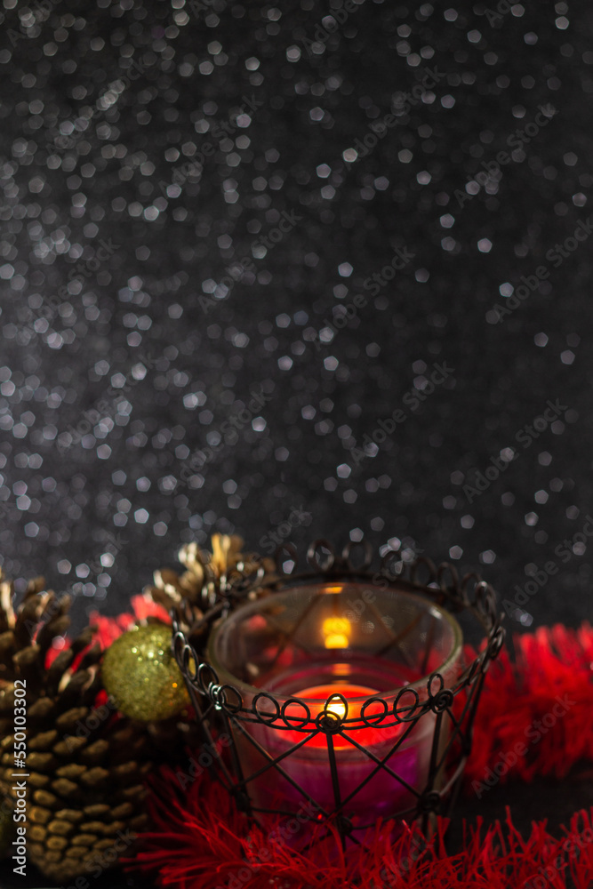 Decoração natalina. Uma vela acesa com bolas douradas, festão e pinhas com  um fundo preto brilhante. Stock Photo | Adobe Stock
