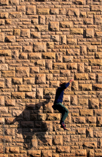 Man buildering on the wall of a University building. photo