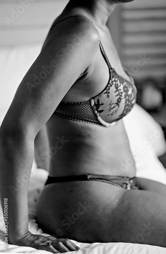 Black woman sitting on bed in deep thought