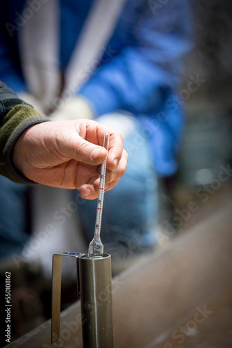 Hand of man using hydrometer,â€ Littleâ€ Suamico, Wisconsin, USA