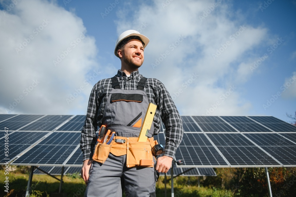 Worker installing solar panels outdoors Worker installing solar panels outdoors