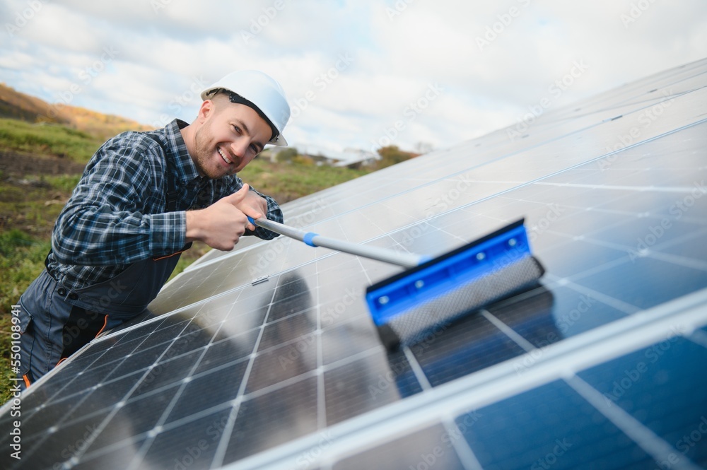 A worker cleaning dust and dirt form solar panels. A worker cleaning dust and dirt form solar panels.
