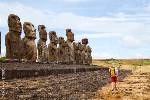 A man walks in front of the famous relics of a historic culture. Moi are lined up on the world's most remote island. photo