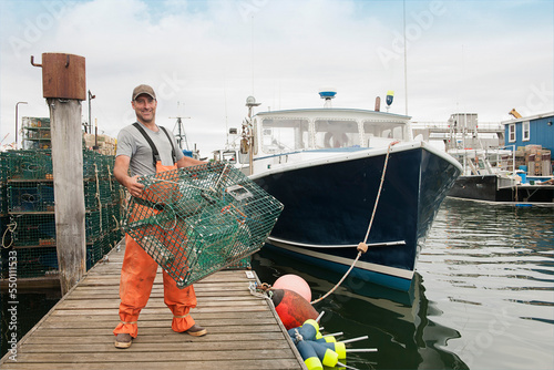 Lobster fisherman carries trap to load on his boat in Casco Bay, Portland, Maine photo