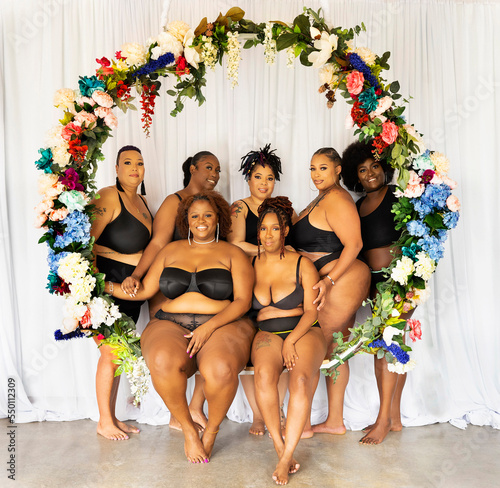 Seven Black women within a flower swing celebrate body positivity