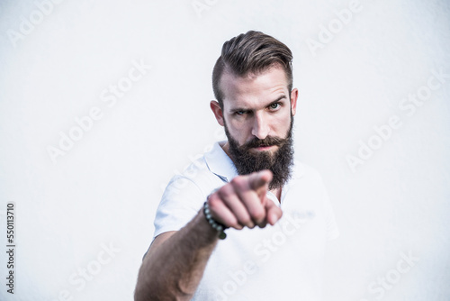 Portrait of a young man pointing in front of wall, Bavaria, Germany