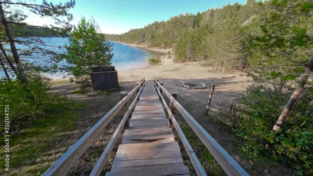 Landscape from the wooden stairs towards the lake in the middle of the forest Landscape from the wooden stairs towards the lake in the middle of the forest