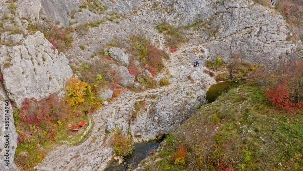 Aerial view on a creek with rocks flowing in autumn colourful forest with trees. Aerial view on a creek with rocks flowing in autumn colourful forest with trees.
