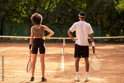 Two young people having a workout at tennis court