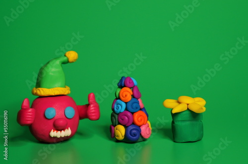 A virus figurine with thumbs up. Green background. Christmas toys.