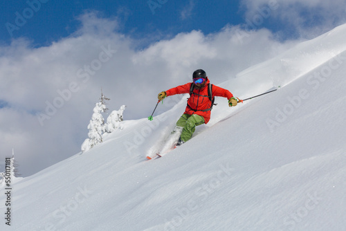 Experienced skier skis down a freeride backcountry slope in loose snow