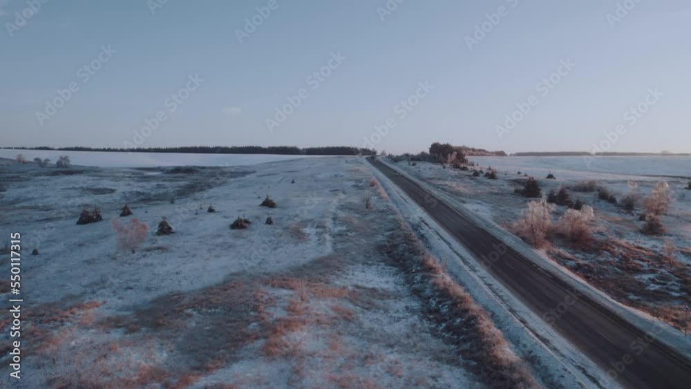 Aerial photography of the highway in winter along the forest at sunset, car traffic in winter. Aerial photography of the highway in winter along the forest at sunset, car traffic in winter.