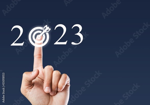 Human finger on 2023 numbers button with target