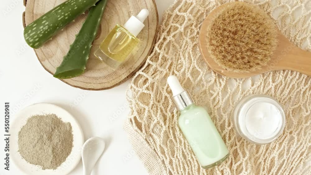 Eco friendly products on white background with green Aloe vera. Gel, fluid, collagen serum, essential oil, salt, massage brush. Natural organic skin care eco-cosmetics. flat lay. High quality 4k