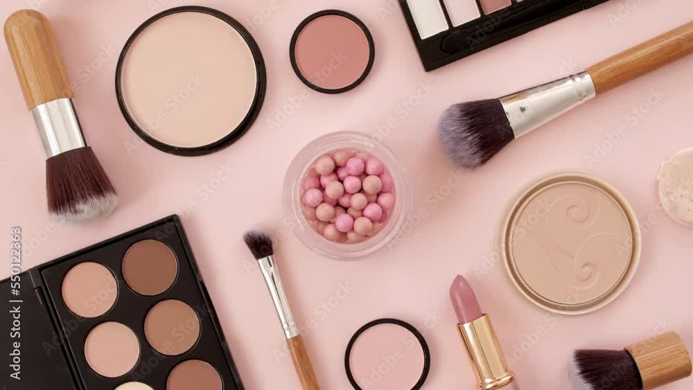 A set of decorative cosmetics on pink background. Makeup products. The beauty of the background with cosmetic facilities. Makeup, the concept of skin care with. High quality 4k footage. 4k