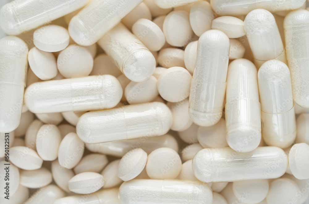 White round pills and capsules texture. Overhead, close up White round pills and capsules texture. Overhead, close up