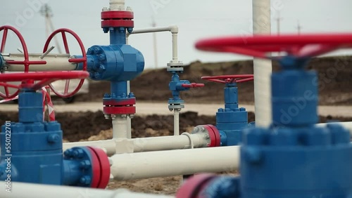 Oil, gas or chemical transportation system at a petrochemical plant. Big red valves and blue pipes photo