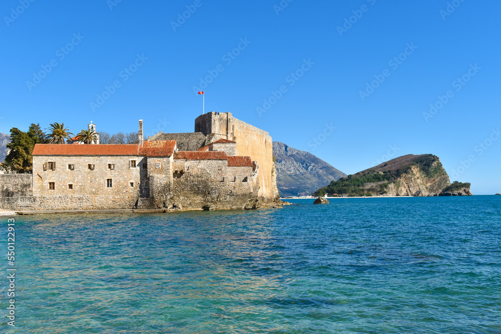 Beautiful coast and the old town of Budva, Montenegro. Adriatic sea water, blue sky.