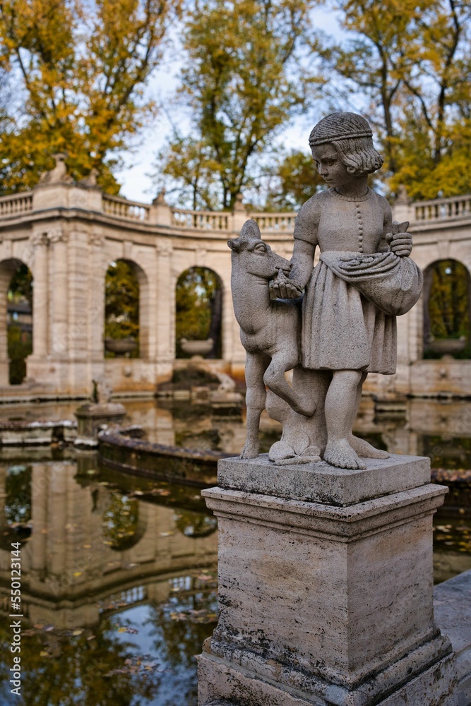 Obraz premium Vertical shot of a figurine by the fairy tale fountain in Volkspark Friedrichshain,Berlin Germany