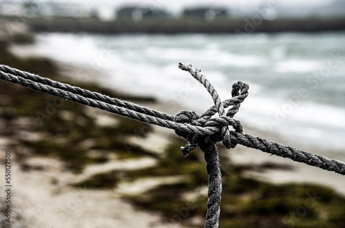 Messy knot on a rope with blurry sea view in the background photo