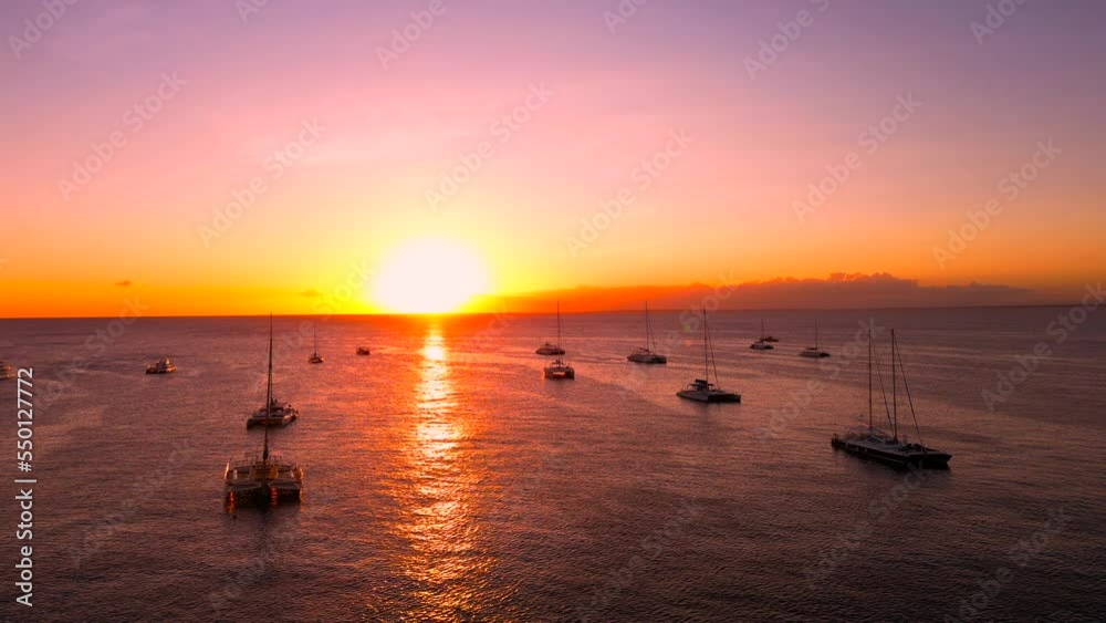 Silhouettes of moored at anchor sailing tourist yachts and catamarans with high mast at sunset. Beautiful nature landscape on the calm sea Silhouettes of moored at anchor sailing tourist yachts and catamarans with high mast at sunset. Beautiful nature landscape on the calm sea