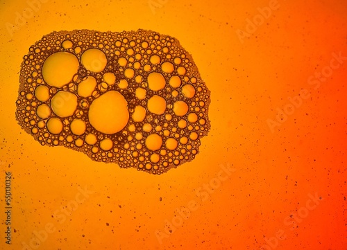 Close-up of bubbles in water with orange background