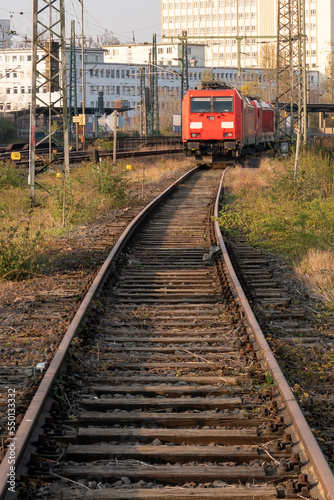 train tracks and front view of a locomotive in the city