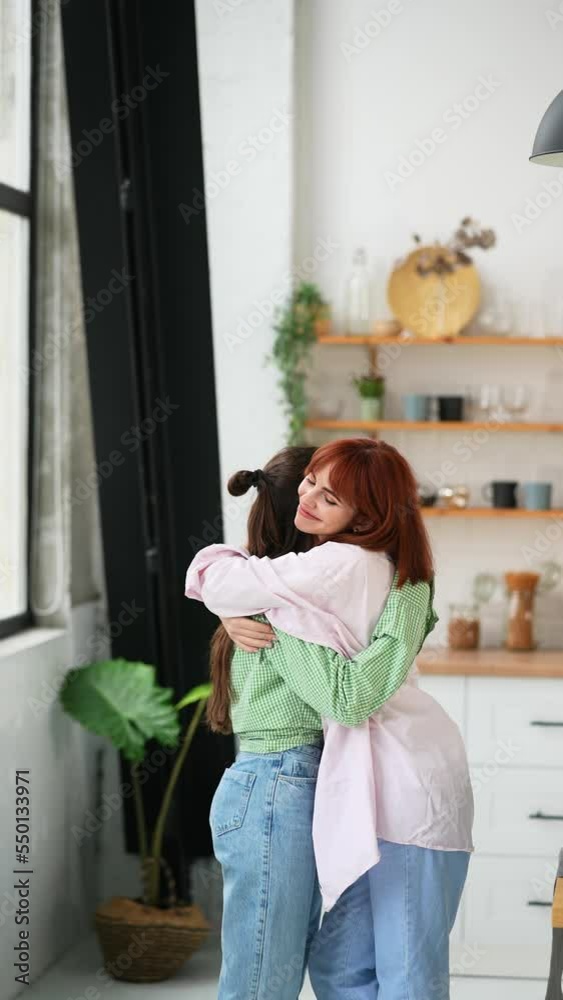 Portrait of two beautiful young women hugging each other at home