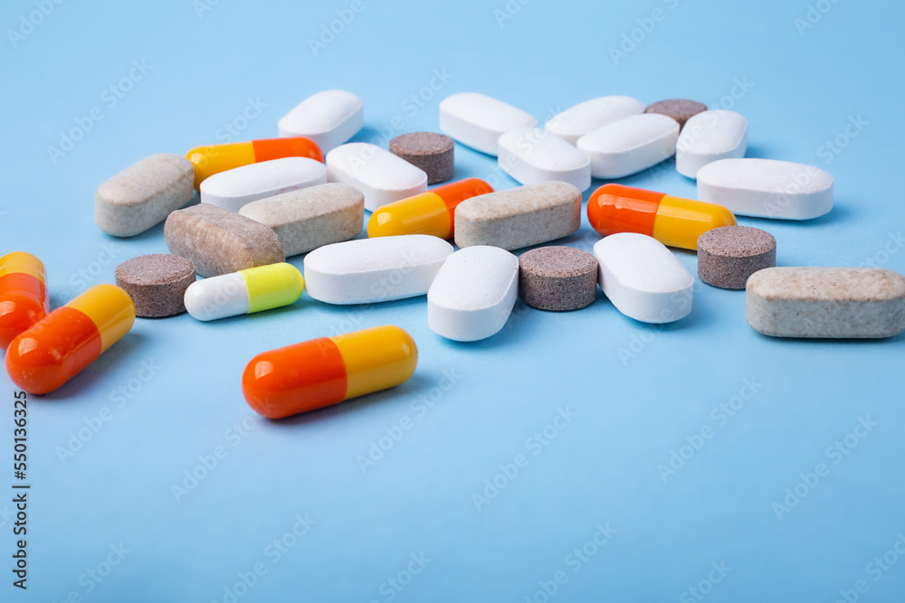 Front view of different pills on blue background,copy space for text. Front view of different pills on blue background,copy space for text.