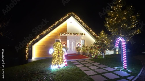Beautifully decorated entrence of house with ornaments, garlands, Christmas trees, glowing lights and different shapes of figures. New Years preparation. Slow motion.  photo