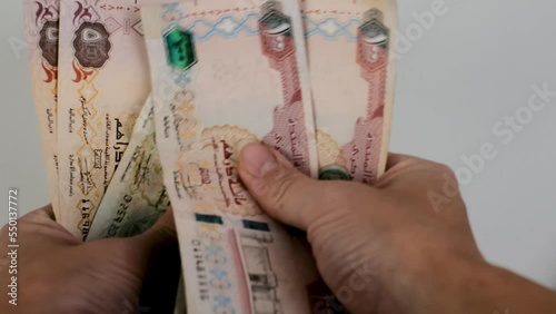 Hand counting United Arab Emirates dirhams on white background. photo