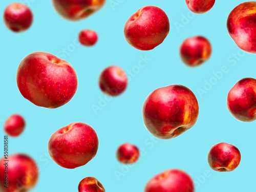 Flying levitating floating red ripe fresh juicy apples in air on blue background. Levity summer fruits. Trendy, minimal,creative food.healthy nutrition