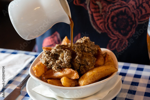 Scottish traditional snack food, hand cut potato chips topped with haggis and gravy photo