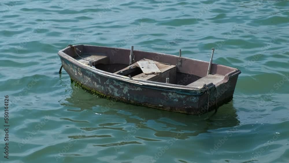 One floating wooden boat for fishing leisure. A view of old wooden fish boat in the open ocean in summer. One floating wooden boat for fishing leisure. A view of old wooden fish boat in the open ocean in summer.