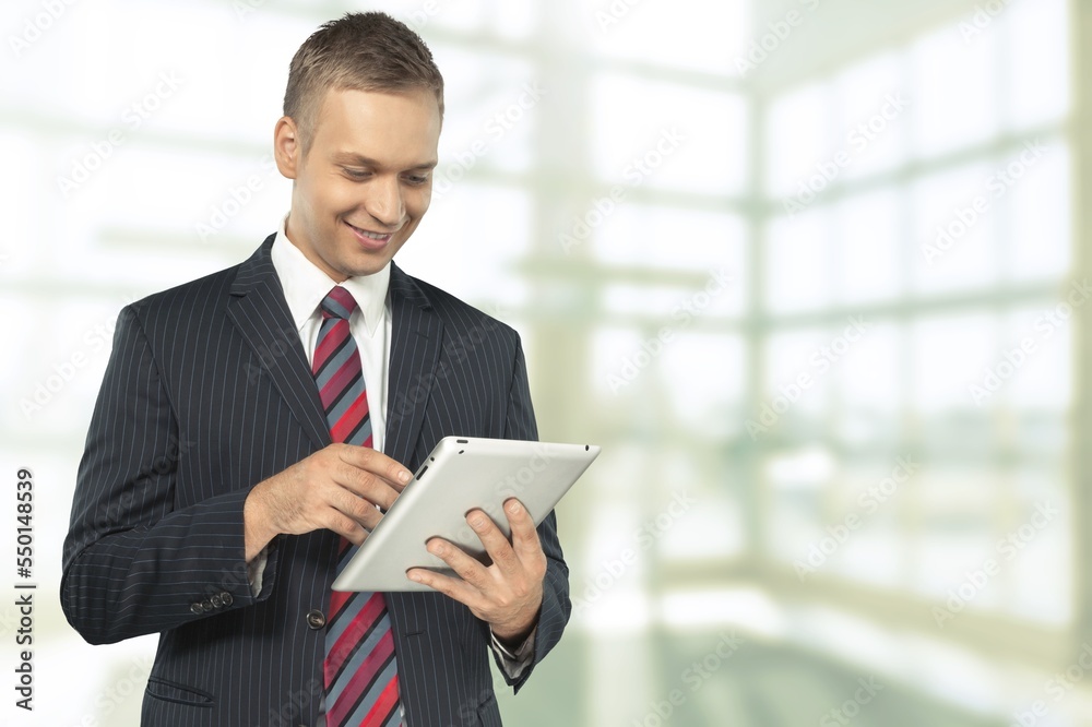 Smiling businessman with digital tablet on city background Smiling businessman with digital tablet on city background