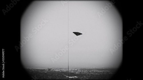 KINESCOPE LOOKING FOOTAGE OF A FLYING SAUCER HOVERING OVER A VALLEY.  FULL HD IN BLACK AND WHITE.