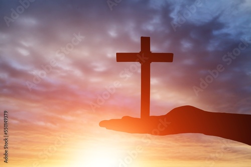 Hands with wooden cross on sky background