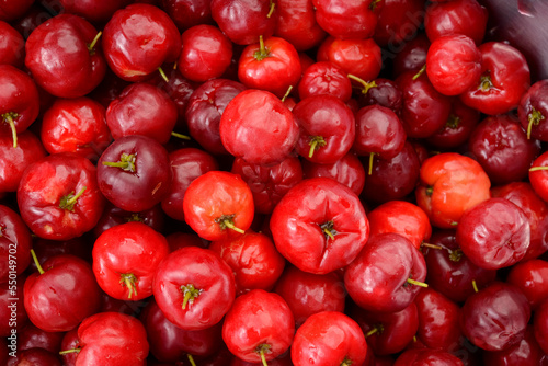 Fresh organic cherry acerolas close-up forming a background pattern. photo