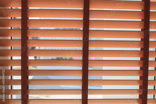 Wooden shutters blinds with the light sunshine. Windows blinds decorate in living room.