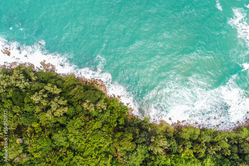 Aerial view green tree forest on sea island with sea wave beach