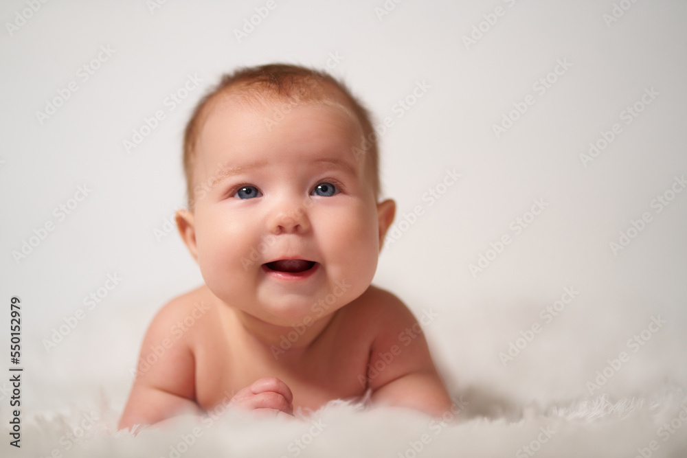 Portrait of an infant on a white background with a cheerful expression of emotion Portrait of an infant on a white background with a cheerful expression of emotion