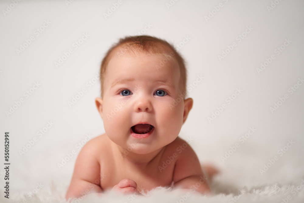 Portrait of an infant on a white background with a cheerful expression of emotion Portrait of an infant on a white background with a cheerful expression of emotion
