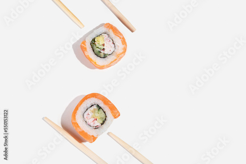 Three Japanese sushi with salmon, dragon rolls on a pastel yellow background. Pop art.