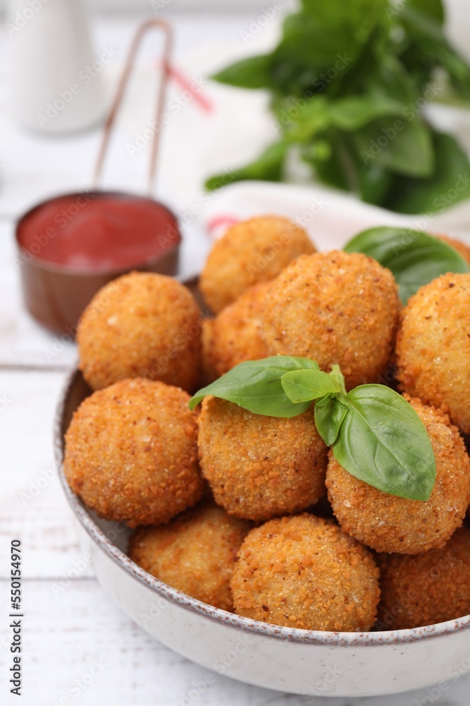 Bowl of delicious fried tofu balls with basil on white wooden table, closeup Bowl of delicious fried tofu balls with basil on white wooden table, closeup