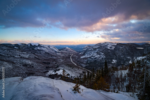 Classic winter landscape. The snowy valley and its sinuous road seen from Dome mountain at dusk  Quebec  Canada