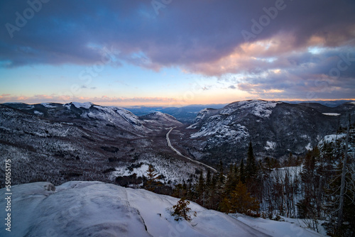 Classic winter landscape. The snowy valley and its sinuous road seen from Dome mountain at dusk, Quebec, Canada