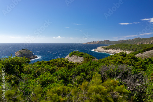 Corsica landscape with white rocks and green mountains and blue sky