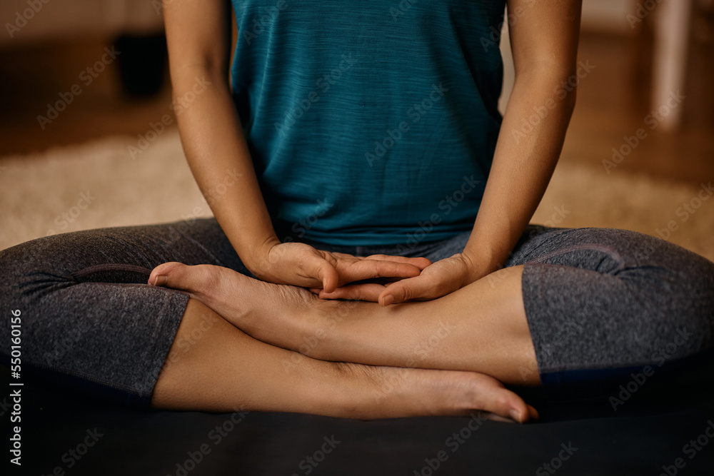 Close up of serene woman meditating while practicing Yoga at home.