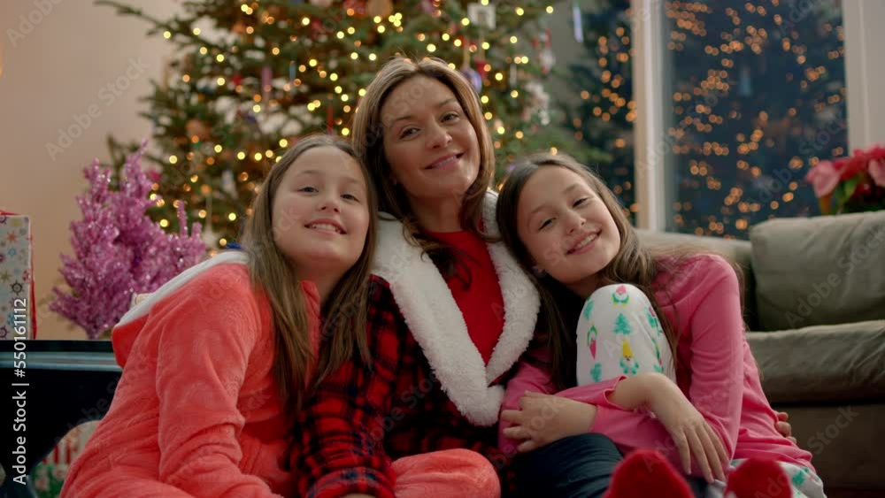 Portrait of a happy family in holiday pajamas smiling and looking at each other on Christmas Day Portrait of a happy family in holiday pajamas smiling and looking at each other on Christmas Day